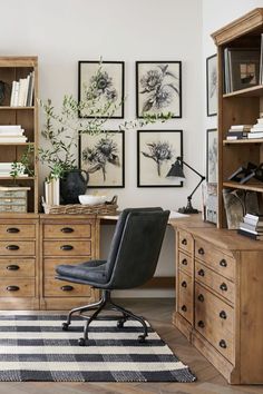 a chair sits in front of a desk with bookshelves and pictures on the wall