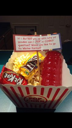 a bowl filled with popcorn, ketchup and marshmallows on top of a table