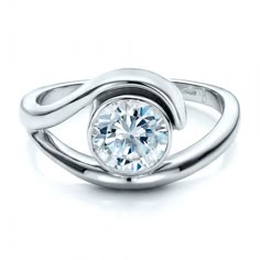 a white gold ring with a round diamond in the center and a twisted band around it