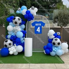 balloons and soccer balls are arranged in the shape of a number four for a birthday party