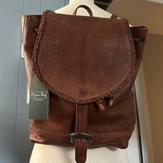 The Myra Lobeth Leather Backpack Is A Beautiful, Retro Design That Features Gorgeous Warm Chocolate Patterned Leather. The Front Has A Buckle-Close Flap With Edge Stitching And A Top Drawstring While The Back Features Adjustable Shoulder Straps In Matching Leather. Due To Natural Cowhide There Are Natural Color/Pattern Variances. Smoke Free Home. Leather Backed Shoulder Bag For Errands, Everyday Satchel With Signature Hardware, Leather Backpack For Errands, Leather Satchel With Signature Hardware For Daily Use, Brown Leather Bag With Signature Hardware, Leather Travel Bag With Signature Hardware, Leather Bag With Signature Hardware For Travel, Leather Shoulder Bag With Signature Hardware For Travel, Brown Satchel Bag With Signature Hardware