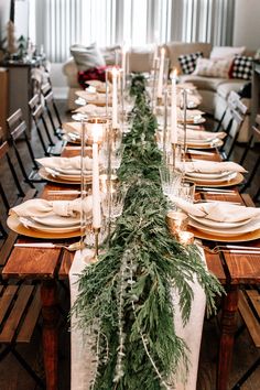 a long table is set with candles and greenery for an elegant christmas dinner party