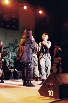 a group of people standing on top of a stage with microphones in their hands