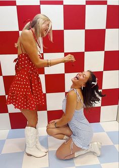 two women in dresses and white boots are laughing