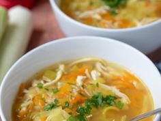 two white bowls filled with chicken noodle soup