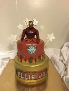 a birthday cake with iron man on top and stars around the edges that says ellis jr