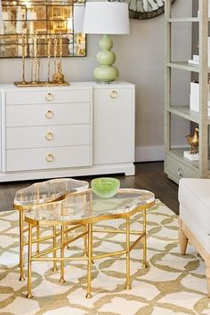 a living room filled with furniture and a large clock on the wall above it's glass top table