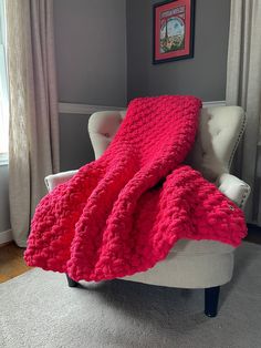 a white chair with a pink blanket on it