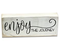 a wooden sign that says enjoy the journey