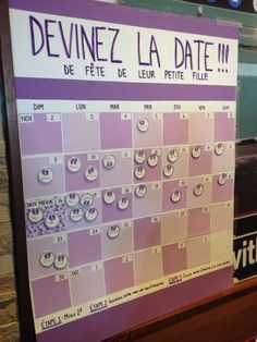 a purple and white calendar on display in a store window with the words devineez la date written below it