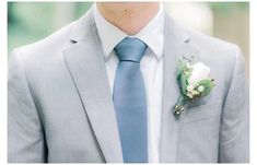 a man in a suit and tie with a boutonniere on his lapel