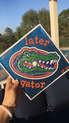 someone is holding up a graduation cap that says later gator