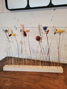 a group of dried flowers sitting on top of a wooden table