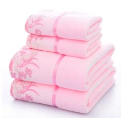 four pink towels stacked on top of each other in front of a white background,