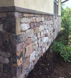 a close up of a stone wall near a building