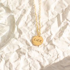 "Not too big and not too small, our 13mm circle necklace, fits just right. A perfect everyday necklace that will layer beautifully with your other chain and pendant necklaces. Engrave a heartfelt word, a special year, or a short name of a loved one. Free Engraving for a limited time! NECKLACE DETAILS ⚬ 14k gold-filled disc and chain. ⚬ Disc measures 13mm (0.51\") ⚬ Chain in your choice of 16\", 18\", or 20\" length ⚬ Spring ring clasp closure. ⚬ Personalized engraving of 1-4 characters (includin Everyday Engraved Charm Necklace With Round Pendant, Minimalist Round Necklace For Personalized Gift, Everyday Engraved Round Coin Necklace, Minimalist Round Necklaces For Personalized Gifts, Everyday Tarnish Resistant Charm Necklace With Round Pendant, Anniversary Round Coin Necklace, 14k Gold Filled Charm Necklace With Coin Pendant, Circle Shaped Yellow Gold Charm Necklace For Gift, Round Personalized Necklace For Her