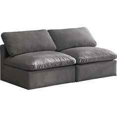 a gray couch with two pillows on it's back and one arm facing the camera