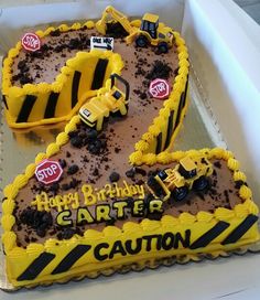 two birthday cakes in the shape of construction vehicles