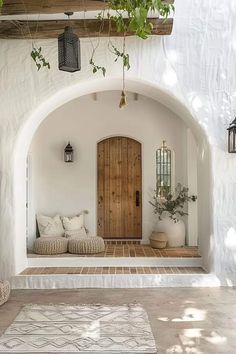 an archway leading to a living room with white walls and wooden doors, surrounded by greenery