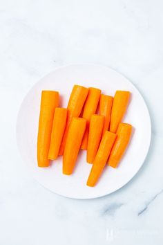 a white plate topped with sliced up carrots