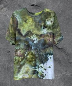 a t - shirt with an abstract design on the front and back, sitting on concrete