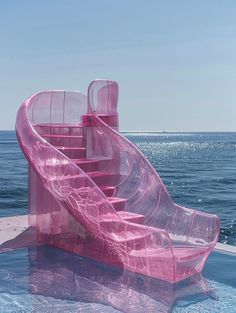 a pink water slide in the middle of an ocean