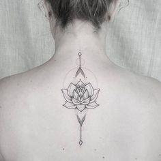 a woman's back with a lotus tattoo on it