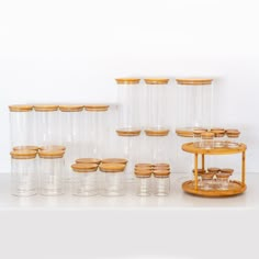 there are many glass containers and wooden lids on the table with each one in front of them