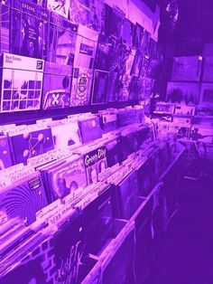 there are many records on the shelves in this store, and one is purple tinted