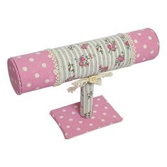 a pink and white polka dot covered telescope on a stand with fabric rolled around it