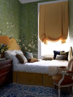 a bedroom with green walls and floral wallpaper