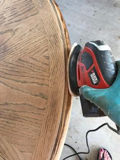 a person using a sander on a wooden table