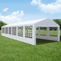 a large white tent sitting on top of a lush green field