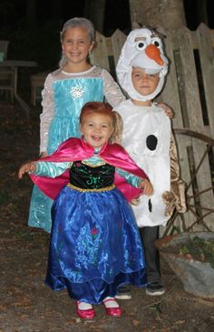 three children dressed up as frozen princesses and snowman, standing next to each other