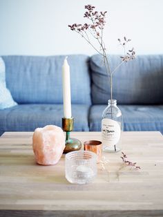 a living room table with candles, vases and other items on it