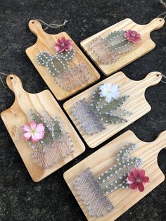 four wooden trays with flowers on them sitting on a black counter top next to some string