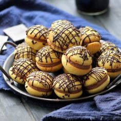 a plate full of cookies with chocolate drizzled on them and sitting on a blue towel