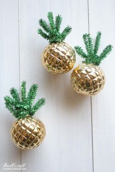 two gold pineapples with green leaves on white wooden background, one is small and the other is large