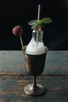 a glass filled with liquid sitting on top of a wooden table