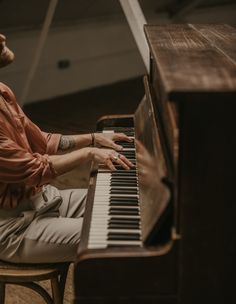 a man sitting at a piano with his hands on the keys