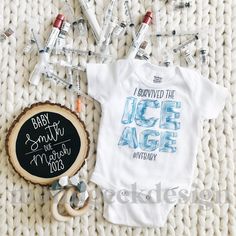 a baby's bodysuit and other items are laid out on a blanket