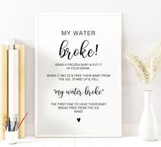 a white framed poster with the words, my water broke in black on it next to some books