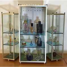 three glass shelves filled with different types of perfumes