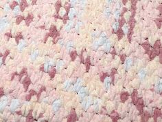 a pink and white crocheted blanket with hearts on it