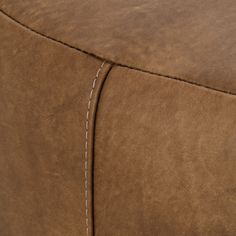 a close up view of a brown leather chair with stitching on the armrests