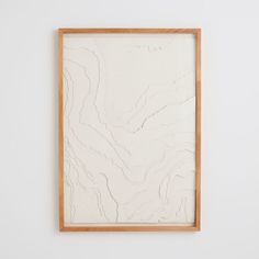 a white wall with a wooden frame hanging on it's side next to a painting