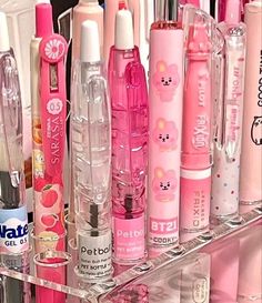 a clear shelf filled with lots of different types of pens