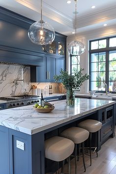 a large kitchen with marble counter tops and blue cabinetry, along with stools