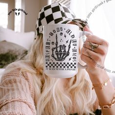 a woman wearing a hat and holding a coffee mug