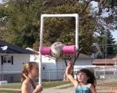 two girls playing with a pink and white basketball hoop